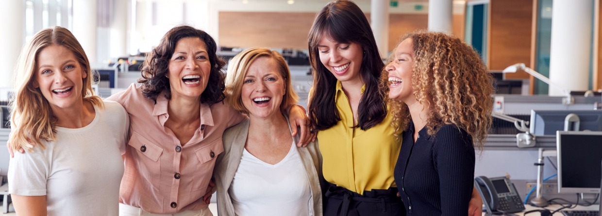 Lachende vrouwelijke collega's die samenwerken in een modern kantoor